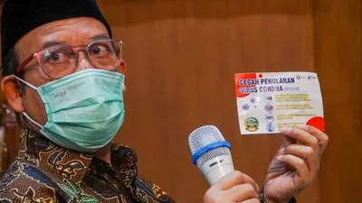 Bupati Banyumas, Achmad Husein menunjukkan stiker imabuan terkait Virus Corona yang akan ditempel di setiap rumah warganya, Senin (16/3/2020). [Suara.com/Anang Firmansyah]